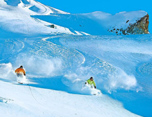 Skiers skiing deep powder off piste