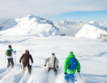 Skiers skiing thigh deep snow