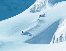 Skiers skiing fresh tracks off piste