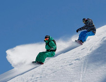 Snowboarders riding off piste
